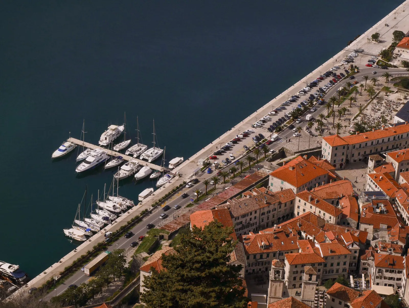 Widok z lotu ptaka na marinę Kotor, nadmorską promenadę i dachy Starego Miasta nad Zatoką Kotorską